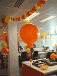Columnas giradas con los colores del partido coronadas por globo gigante