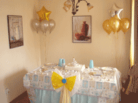Mesa decorada para comuni�n, con ramos de globos a los lados.